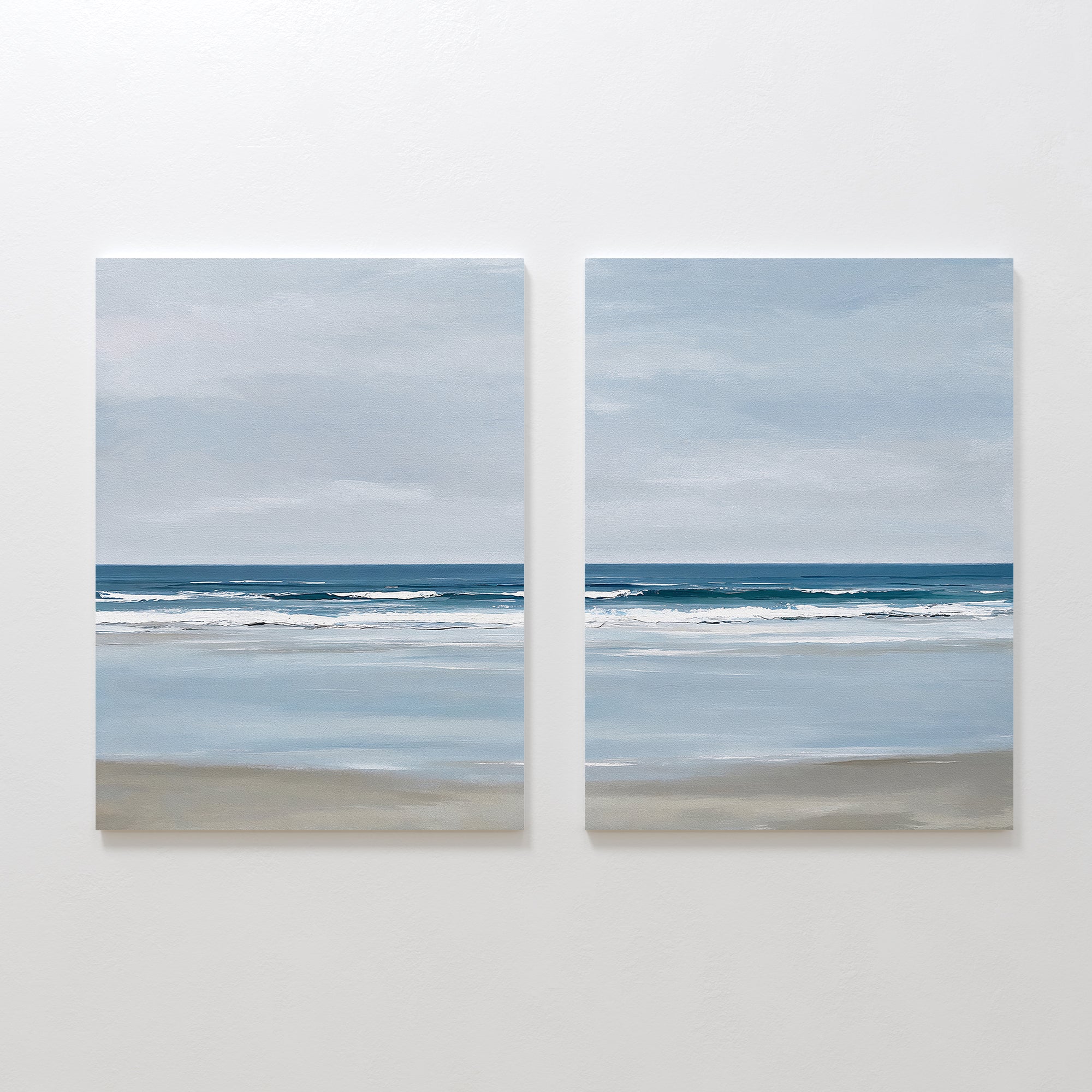 The Soft Tide Set of 2 features side-by-side paintings of a calm, cloudy seascape with gentle waves and sandy shores, bringing peaceful coastal wall art and serene ocean views to your bedroom decor.