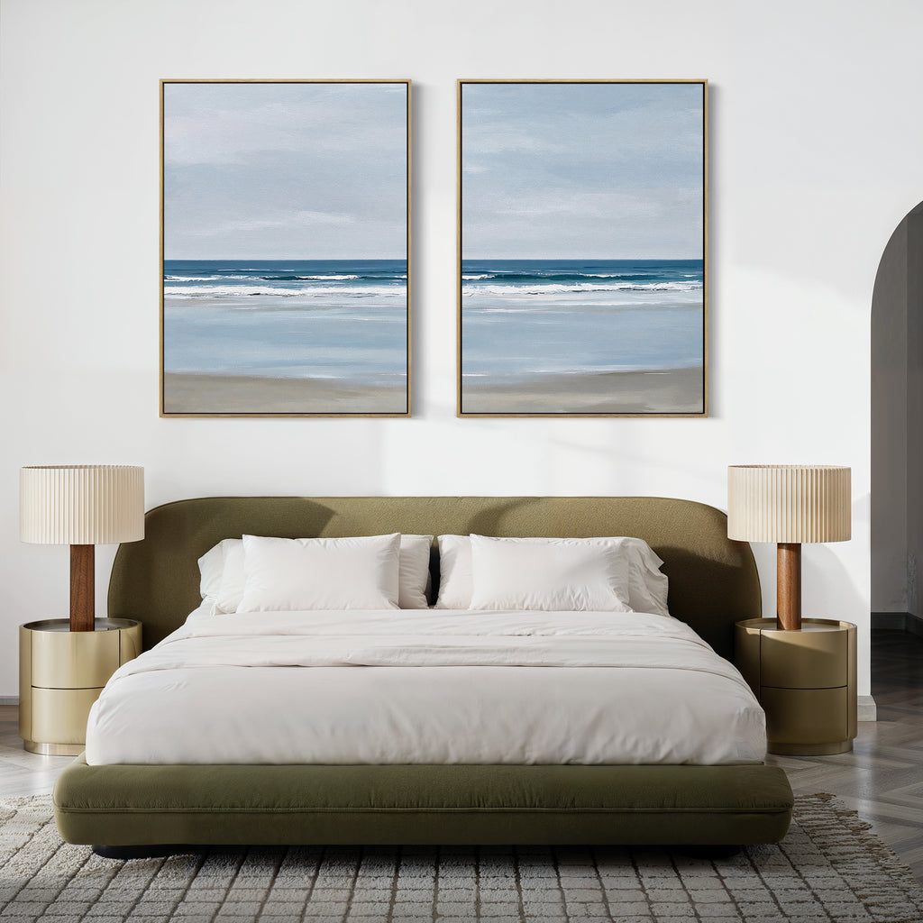 A modern bedroom with a green upholstered bed, white bedding, two beige nightstands with matching lamps, and the Soft Tide Set of 2 minimalist ocean landscape wall art above the bed completes the serene decor.