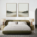 A modern bedroom with a low olive-green bed, white bedding, two beige nightstands with matching lamps, a textured rug, and the Soft Valley Set of 2 landscape wall art pieces displayed above the bed.