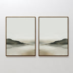 The Soft Valley Set of 2 features framed landscape wall art with muted green, gray, and beige tones depicting gentle hills and a hazy sky over water—an ideal, peaceful accent for minimalist decor on a plain white wall.