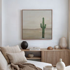 A cozy, neutral-toned living room features a beige sofa with cushions, minimalist decor on a wooden sideboard, and the Solitary Rise Canvas Art framed above.