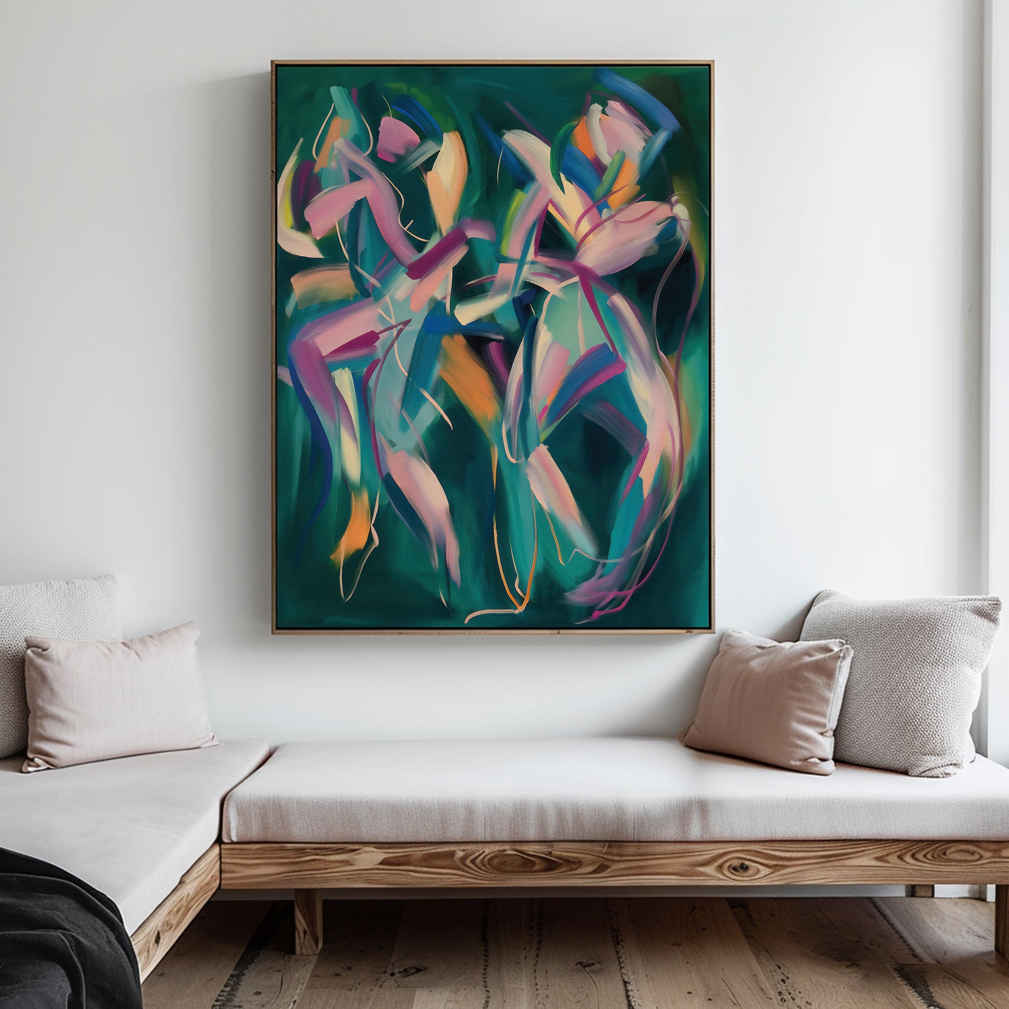 The Spiralling Forms Abstract Canvas Art, featuring vivid pink, orange, and blue swirling brushstrokes, hangs above a minimalist wooden sofa with light cushions in a modern living room with white walls.