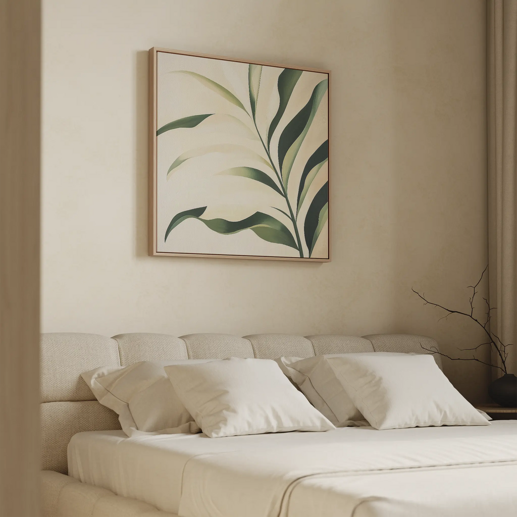 A minimal bedroom featuring a beige bed, white pillows, and the Spring Foliage Canvas Art with a green leaves print above the headboard. A small branch in a vase on the nightstand complements the modern decor.