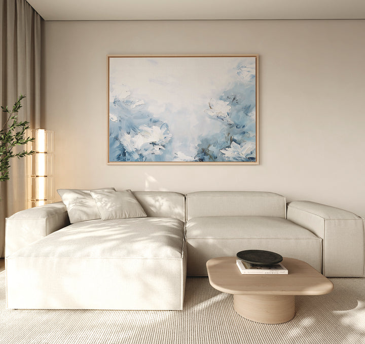 A modern living room featuring a light beige sectional sofa, the Spring Hues Canvas Art – Horizontal above, a low wooden coffee table with a black bowl, and sheer curtains—ideal for creating effortless living room decor.