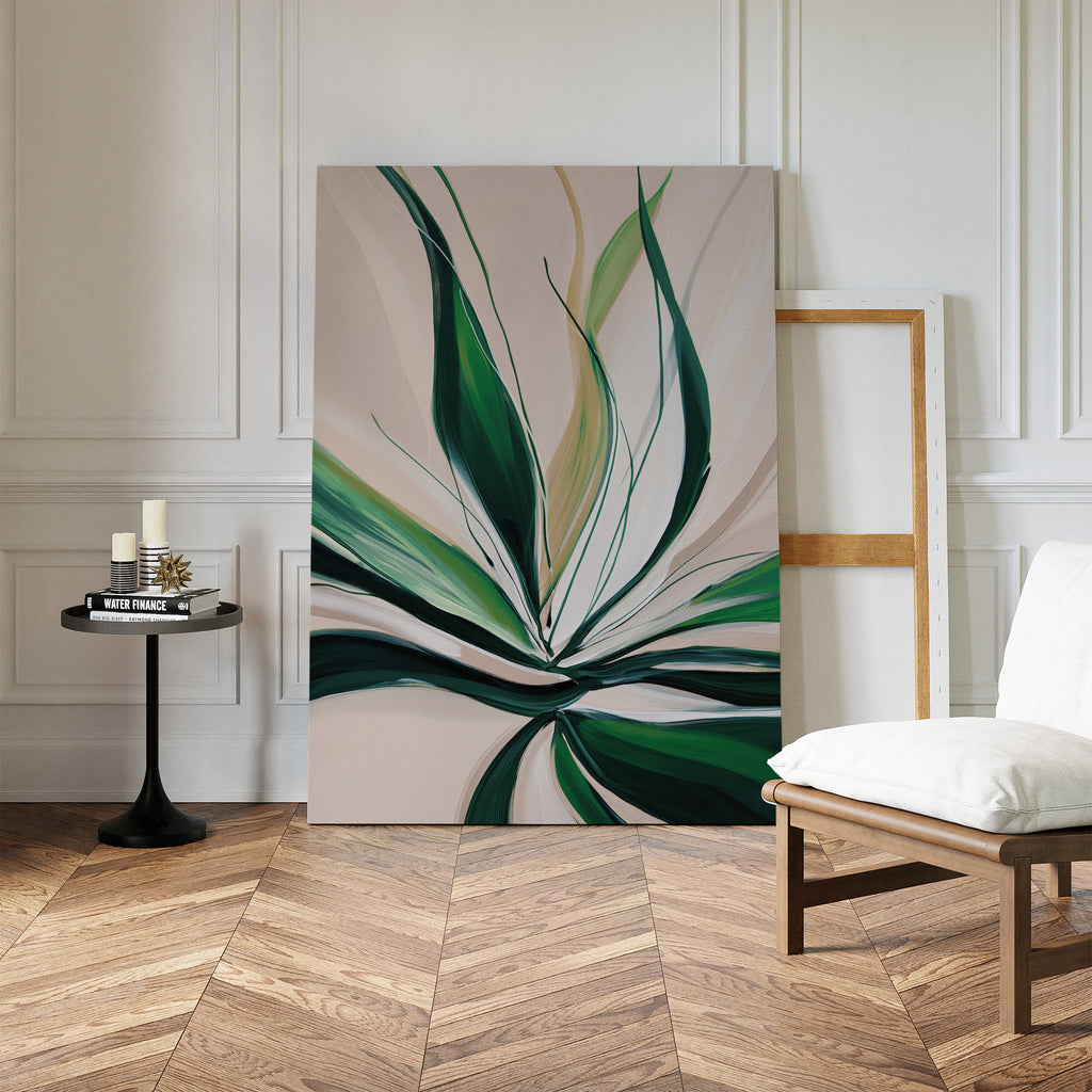 Springs Essence Abstract Canvas Art with green and cream leaf motifs leans against a white paneled wall. Nearby, a small round table displays candles and books, next to a white cushioned chair on the wooden herringbone floor.