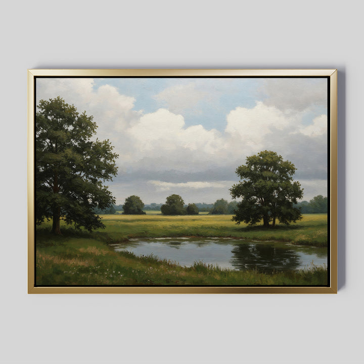 The Still Grove Canvas Art features a framed painting of a tranquil landscape with a pond, open grassy fields, and tall leafy trees beneath a cloudy sky on a simple light gray background.