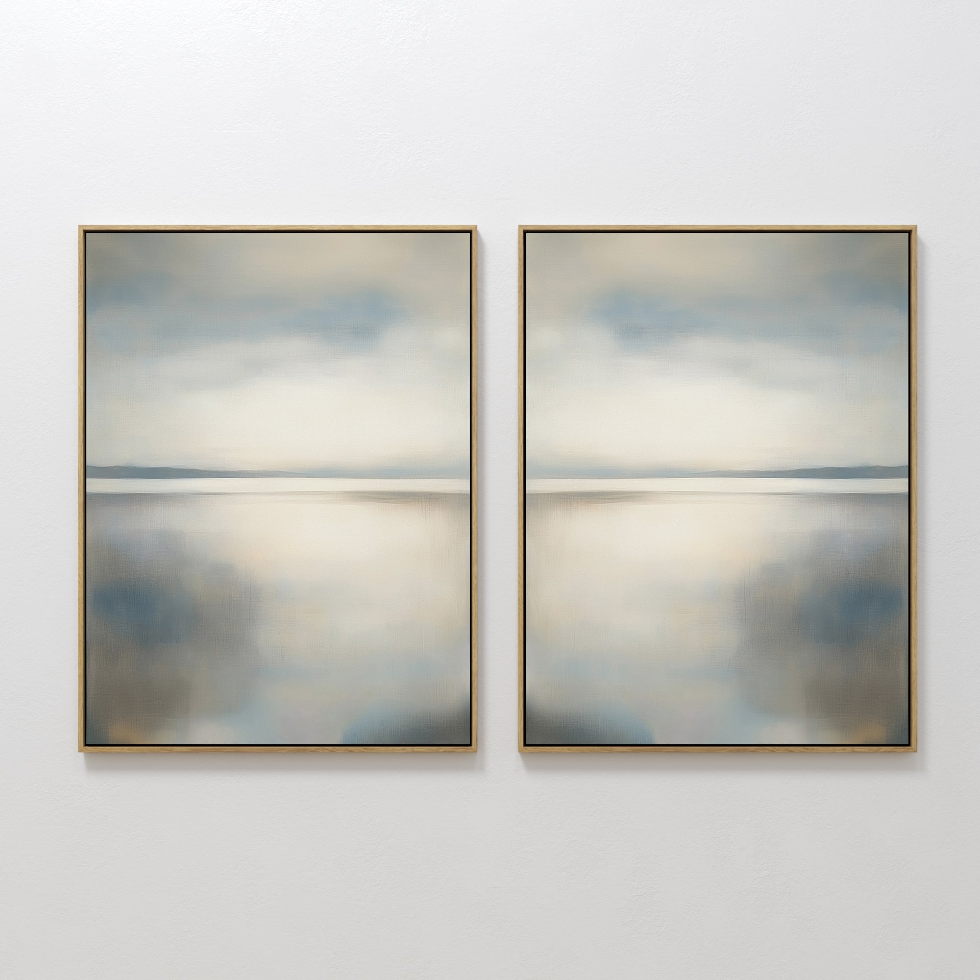 The Still Horizon Set of 2 features framed abstract art depicting a tranquil shoreline with calm water and cloudy skies in muted blue, gray, and beige. This minimalist wall art adds a peaceful, Nordic Park-inspired vibe to any space.
