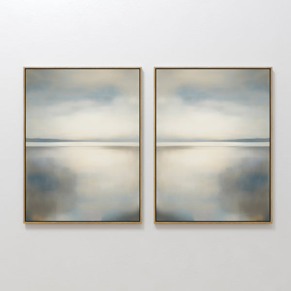 The Still Horizon Set of 2 features framed abstract art depicting a tranquil shoreline with calm water and cloudy skies in muted blue, gray, and beige. This minimalist wall art adds a peaceful, Nordic Park-inspired vibe to any space.
