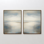 The Still Horizon Set of 2 features framed abstract prints, each portraying a calm shoreline in muted blue, gray, and beige—minimalist wall art that evokes tranquility for any room.