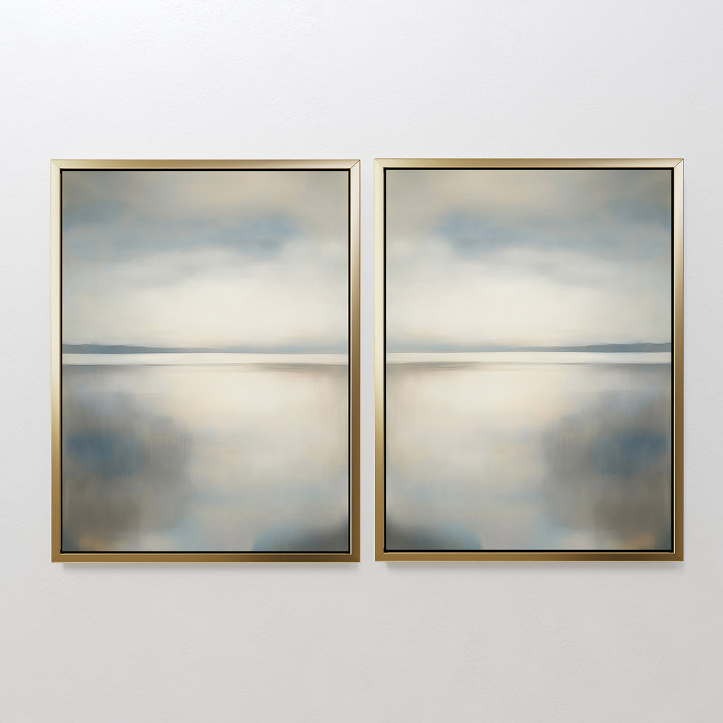 The Still Horizon Set of 2 features framed abstract paintings side by side, showing calm water and sky in muted blue, beige, and gray with gold frames. This minimalist wall art brings a serene shoreline vibe to your space.