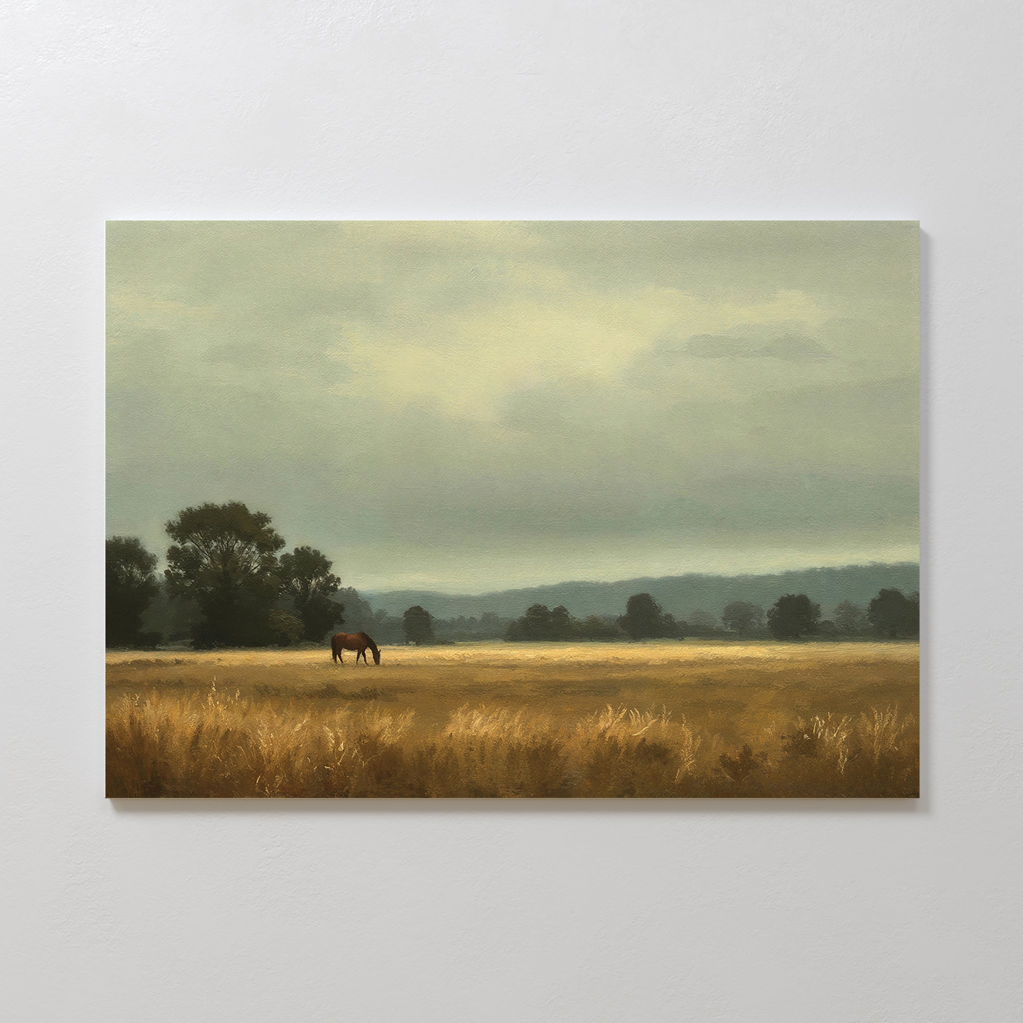 Still Morning Canvas Art captures a serene countryside with a lone horse grazing in a golden field beneath a muted, cloudy sky—perfect as wall art to bring calmness and beauty to your home.