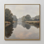 The Still Riverbank Canvas Art showcases a calm river with trees and grassy banks beneath a cloudy sky, offering soft reflections on the water—ideal minimalist wall art for creating tranquil bedroom décor.