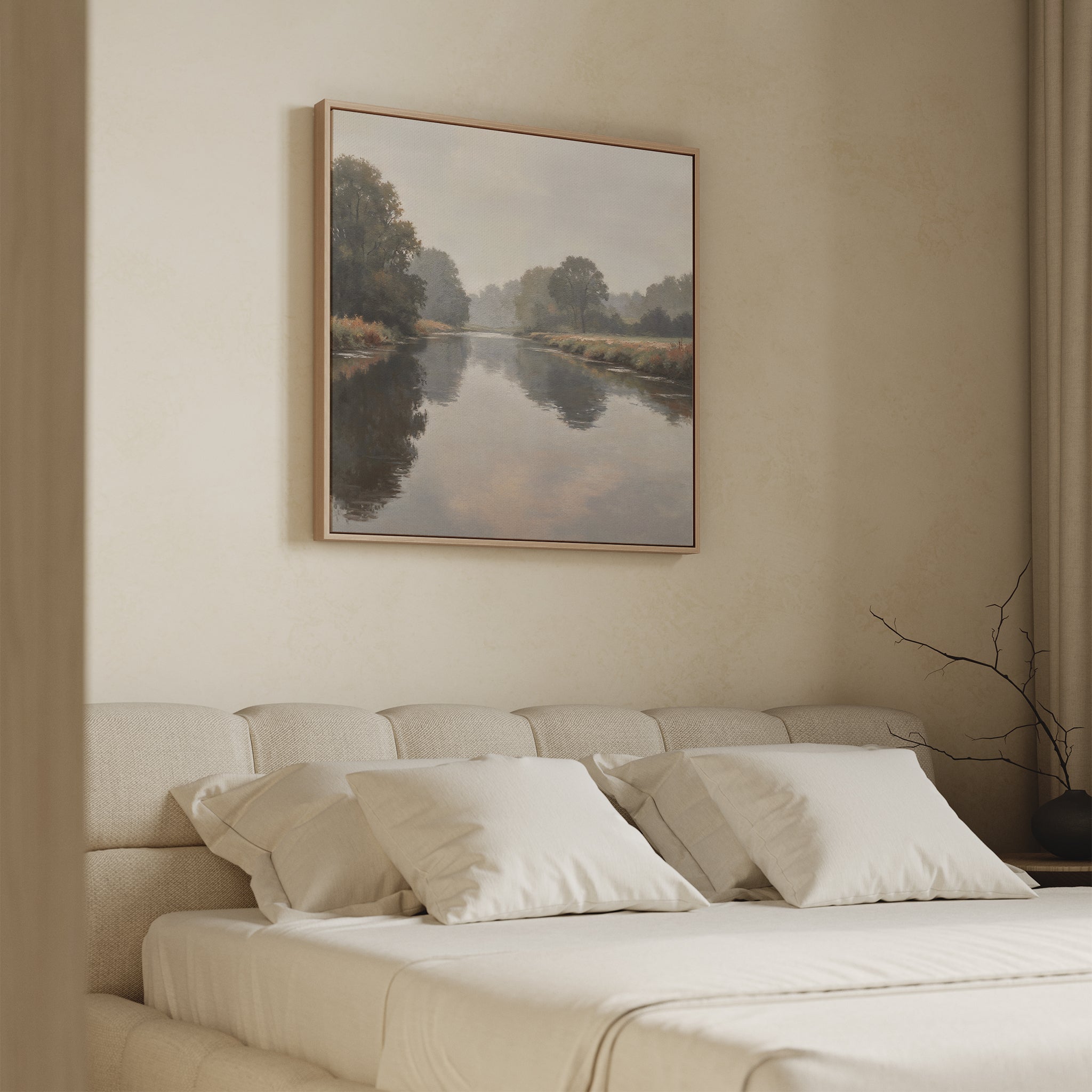 A neutral-toned bedroom with a beige bed and four pillows features the Still Riverbank Canvas Art above the headboard. Soft light enhances the serene, minimalist space, creating a calming atmosphere ideal for refined bedroom decor.