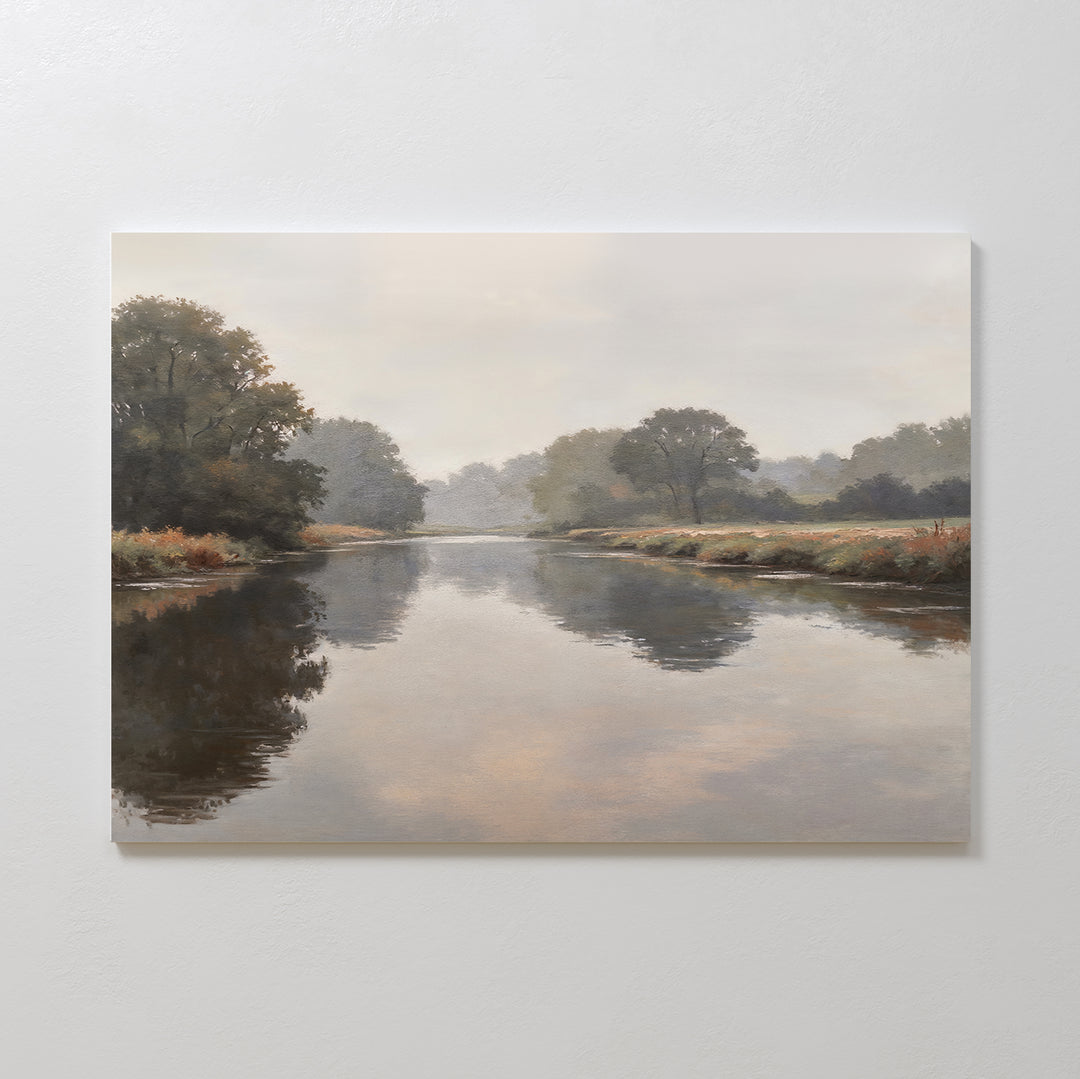 The Still Riverbank Canvas Art – Horizontal features a calm river reflecting trees and an overcast sky in soft, muted colors, ideal as minimalist wall art for serene bedroom decor. Displayed mounted on a white wall.