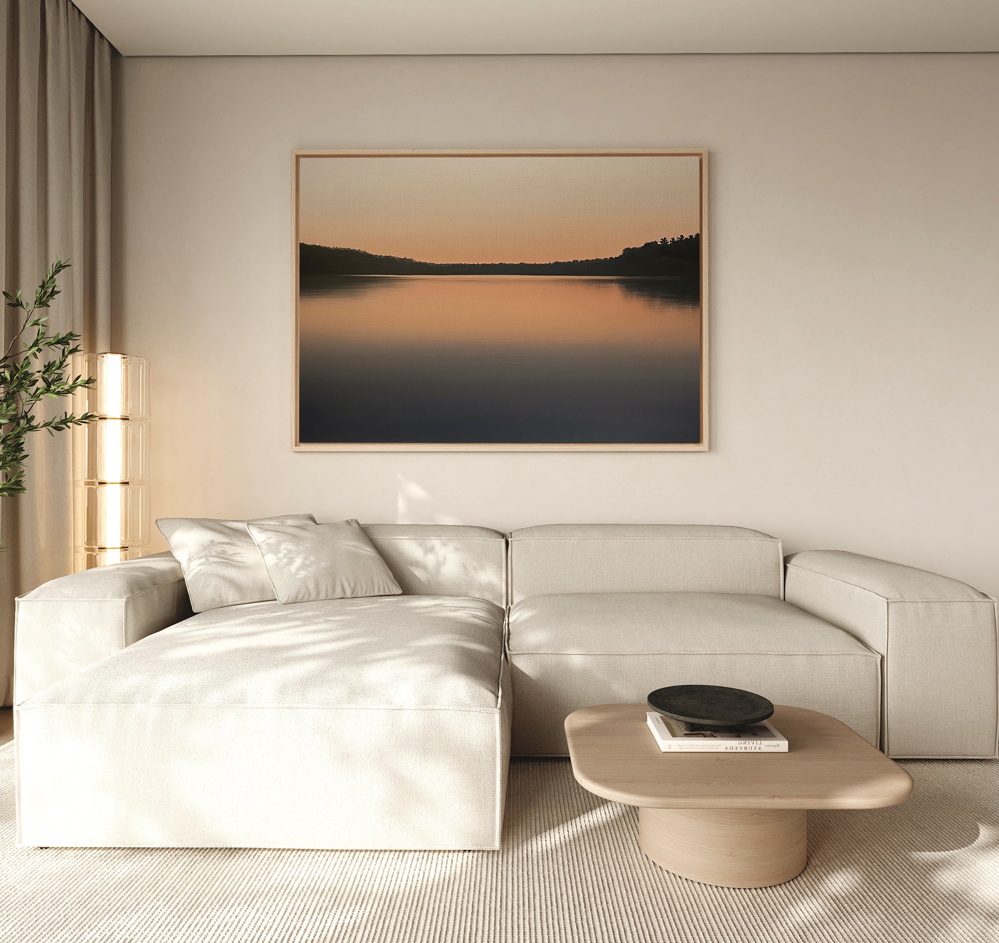 A modern living room with a light beige sectional sofa, low wooden coffee table, and a potted plant. The Still Waters Canvas Art – Horizontal above the sofa and neutral-toned minimal decor create a serene atmosphere.