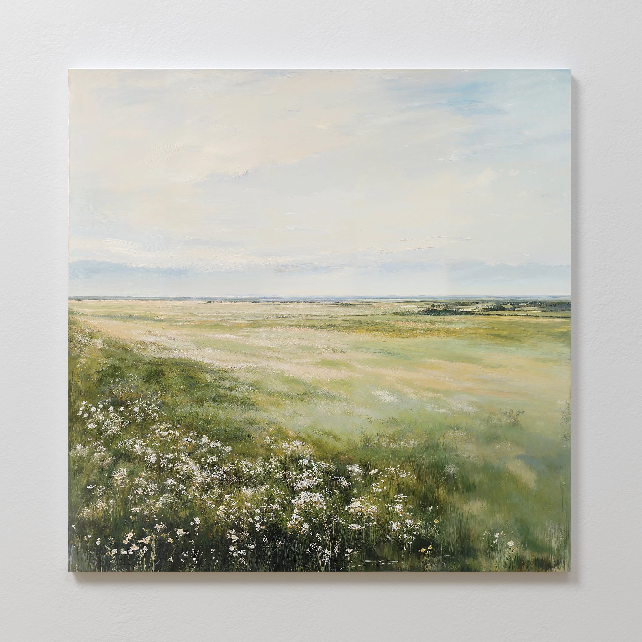The Summer Meadow Canvas Art features a serene sunlit meadow with tall green grass and white wildflowers under a soft blue sky, capturing nature’s beauty and adding charm to any living room decor.