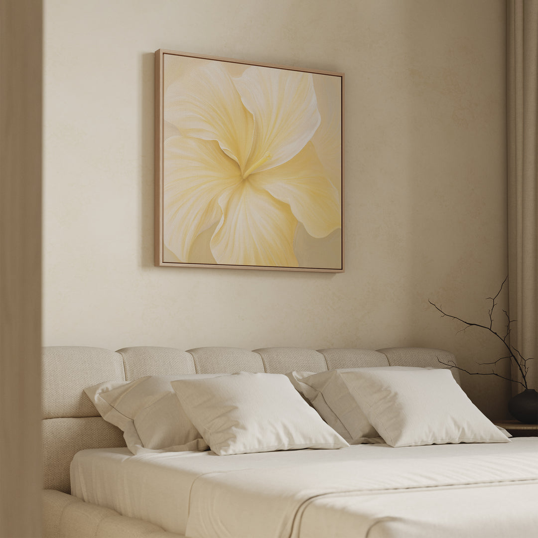 A modern bedroom features a beige upholstered bed with white bedding and pillows. Above the bed hangs the Sunlight Curve Canvas Art, adding a soft yellow accent to the minimal, neutral-toned decor with a bare branch in a vase.