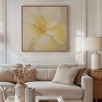 A modern living room with a beige sofa, neutral pillows, and a side table with a cream lamp. Dried flowers and the Sunlight Curve Canvas Art in soft yellow complete the minimalist décor above the sofa.