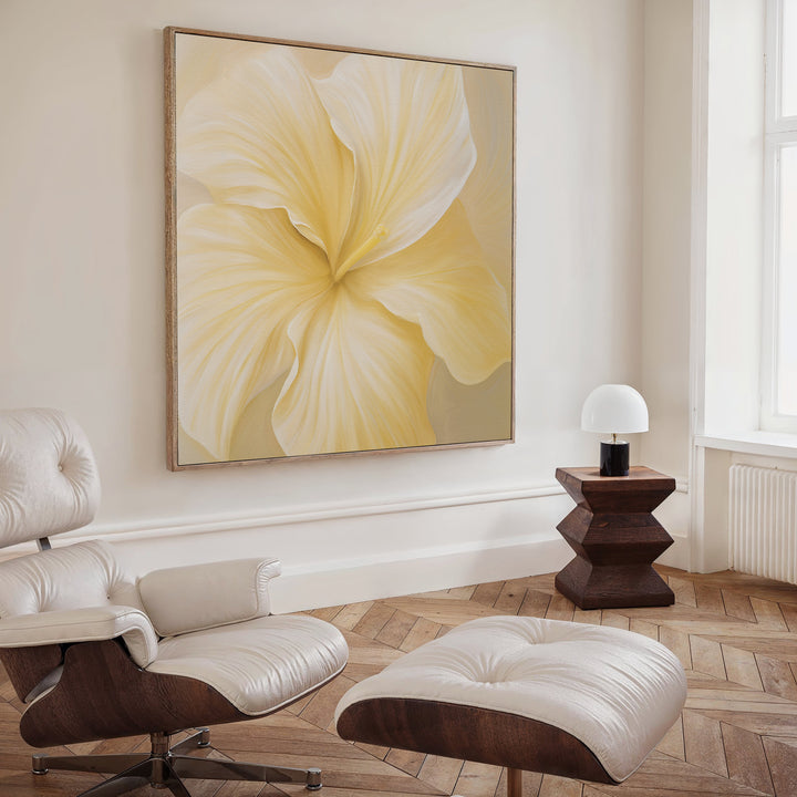 A modern living room with a white leather lounge chair and ottoman, wooden side table and lamp, and the Sunlight Curve Canvas Art on a cream wall—a perfect touch for elegant, minimalist living room decor.