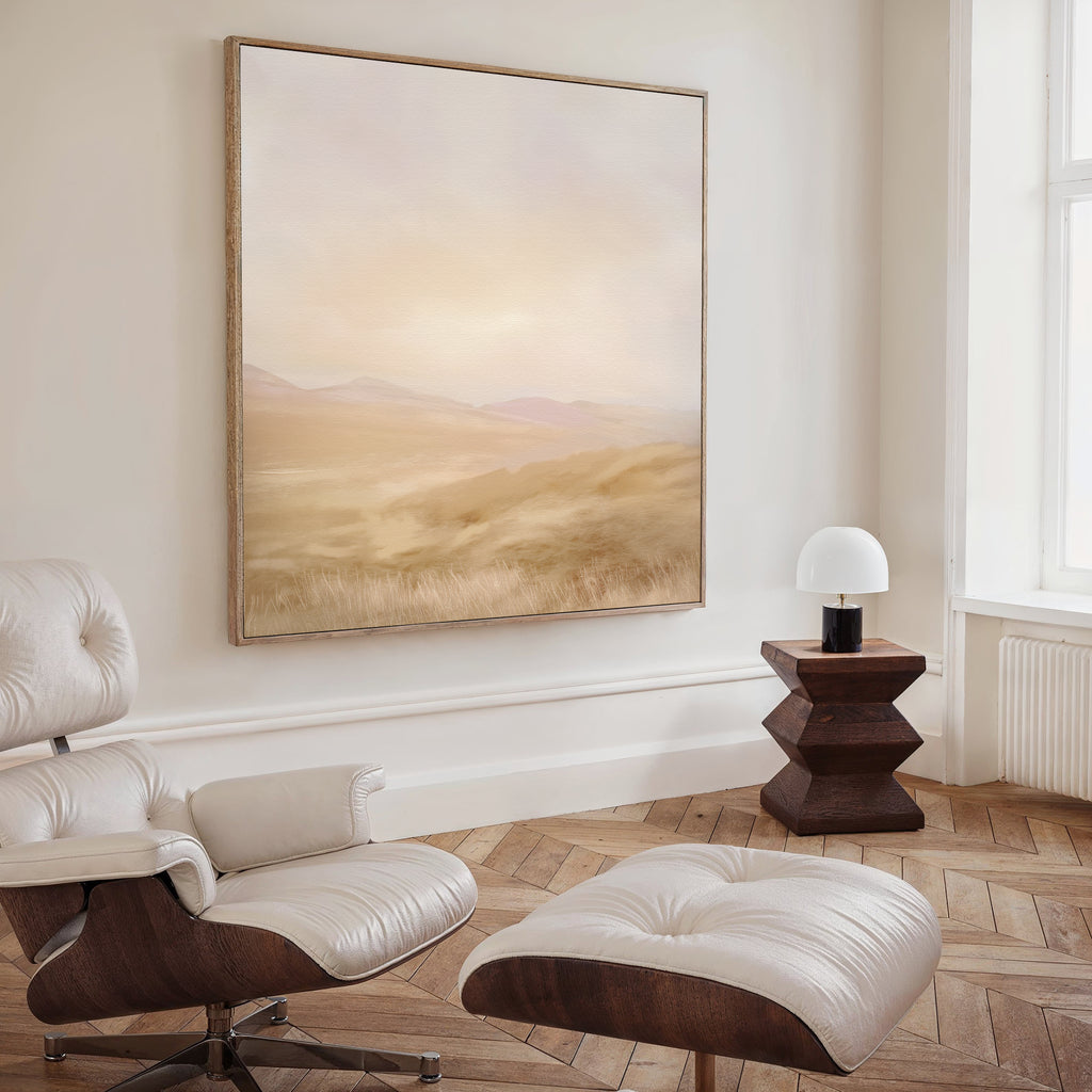 A minimalist living room with a white leather lounge chair and ottoman, a geometric wooden side table with a small lamp, and the Sunlit Meadows Abstract Canvas Art in soft beige—perfect for subtly styled modern interiors.
