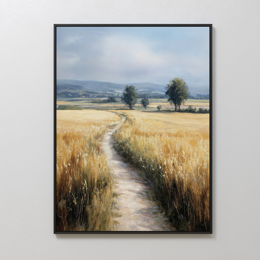 The Sunlit Passage Canvas Art features a framed, nature-inspired print of a dirt path through golden wheat toward distant trees and blue mountains under a cloudy sky, bringing serenity and natural beauty to any space.