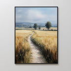 The Sunlit Passage Canvas Art features a framed, nature-inspired print of a dirt path through golden wheat toward distant trees and blue mountains under a cloudy sky, bringing serenity and natural beauty to any space.