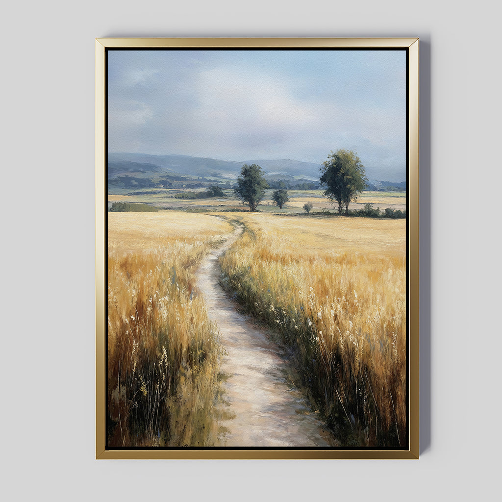 The Sunlit Passage Canvas Art is a large, framed print depicting a country path through golden fields toward two distant trees under a cloudy sky. It features a gold frame with a minimalist gray background for stylish, nature-inspired wall decor.