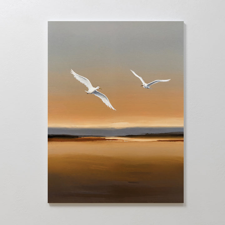 Sunset Flight Canvas Art features two white birds soaring over a tranquil, golden-brown landscape at sunset with a soft gradient sky—ideal minimalist wall art to enhance your serene bedroom decor.