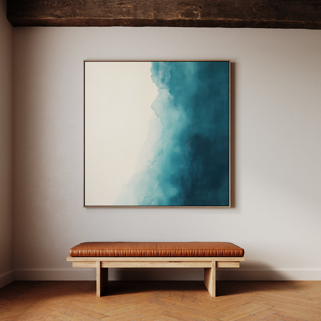 A minimalist interior features the Teal Tide Canvas Art in blue and white tones above a wooden bench with a brown leather cushion, set against a light wall and herringbone wood floor.