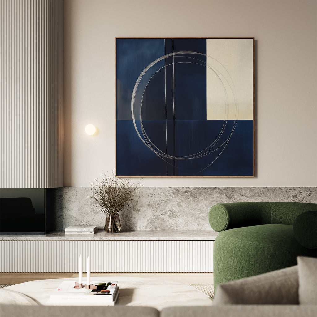 Modern living room featuring The Orbit Canvas Art with bold blue and cream circular patterns above a green curved armchair, marble console, minimalist decor, and books—a perfect accent for any modern home.