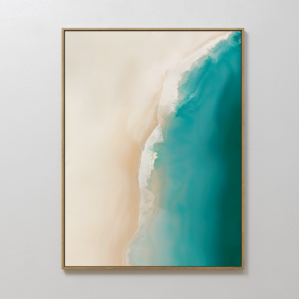 The Beach Abstract Canvas Art showcases an aerial view of beige sand merging into turquoise blue water for a calm, minimalist coastal vibe. Ideal as living room decor, its shown on a plain white wall.