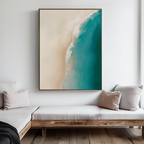 A modern living room with light wood furniture, cream cushions, and The Beach Abstract Canvas Art—a coastal wall piece featuring an aerial view of turquoise water and sandy shore to elevate your decor.