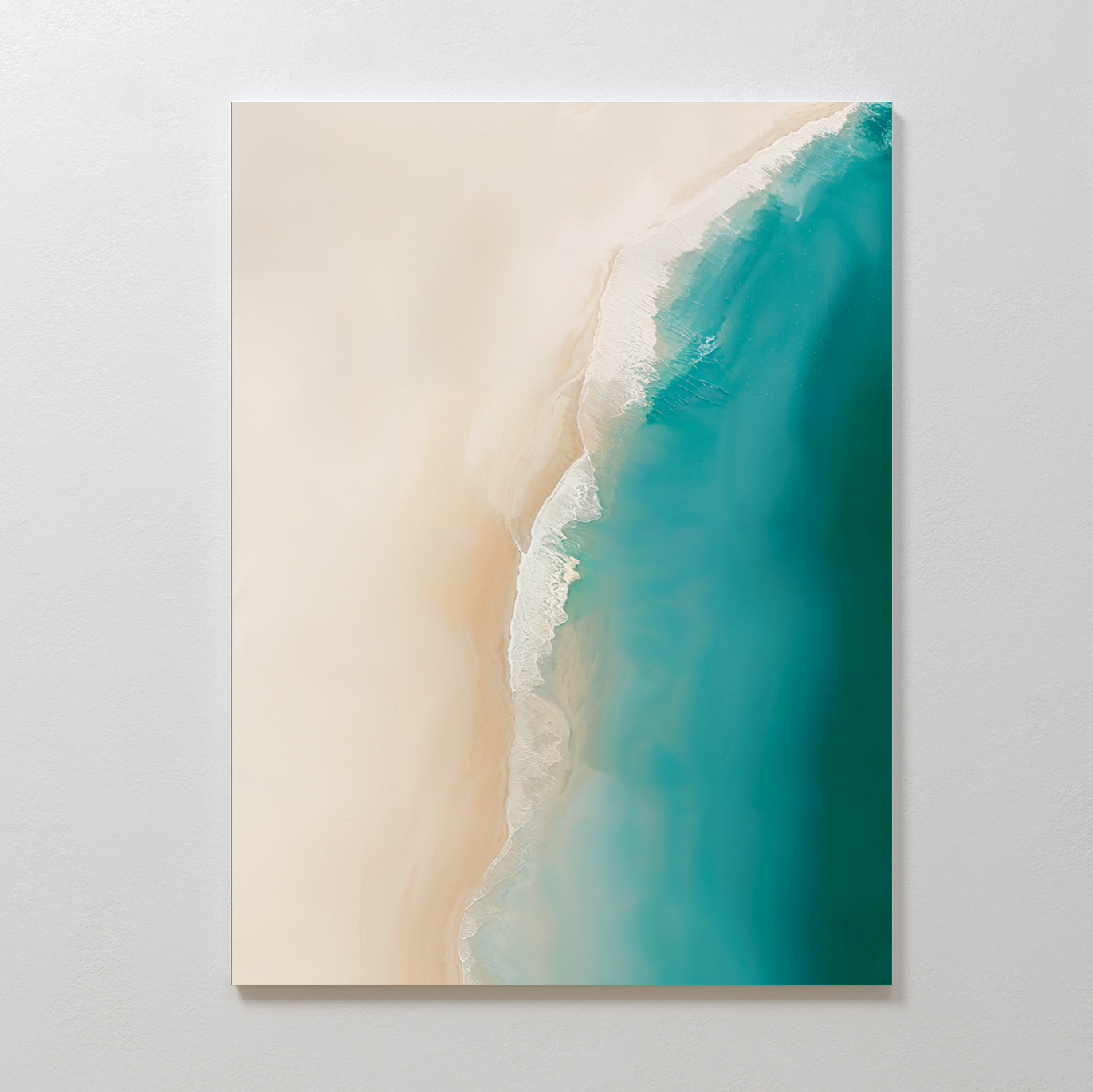 The Beach Abstract Canvas Art features a minimalist aerial view of beige sand merging with turquoise waves under natural light, mounted on a white wall—ideal for bringing serene coastal vibes to your living room decor.