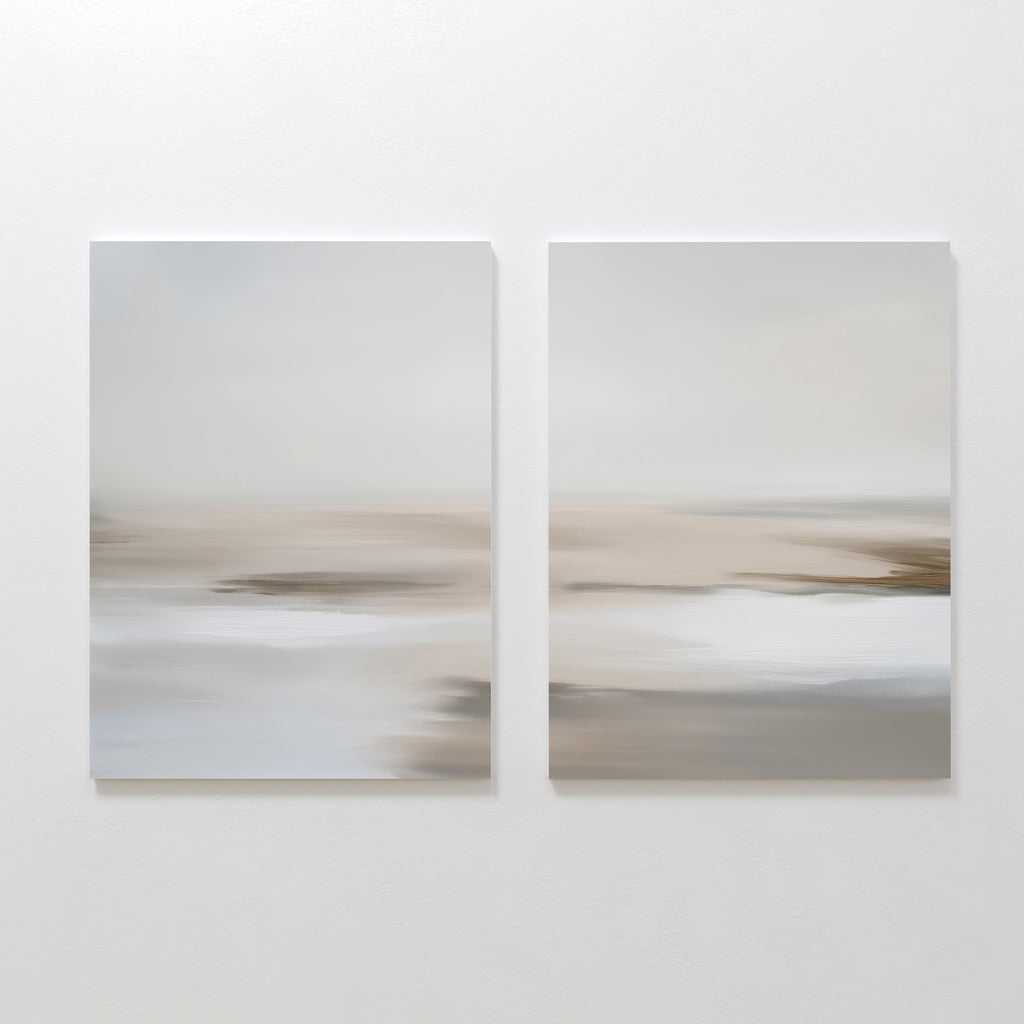 The Tranquil Shifts Set of 2 features abstract paintings in soft beige, white, and gray tones, side by side on a white wall—perfect minimalist wall art to create a serene living room atmosphere.