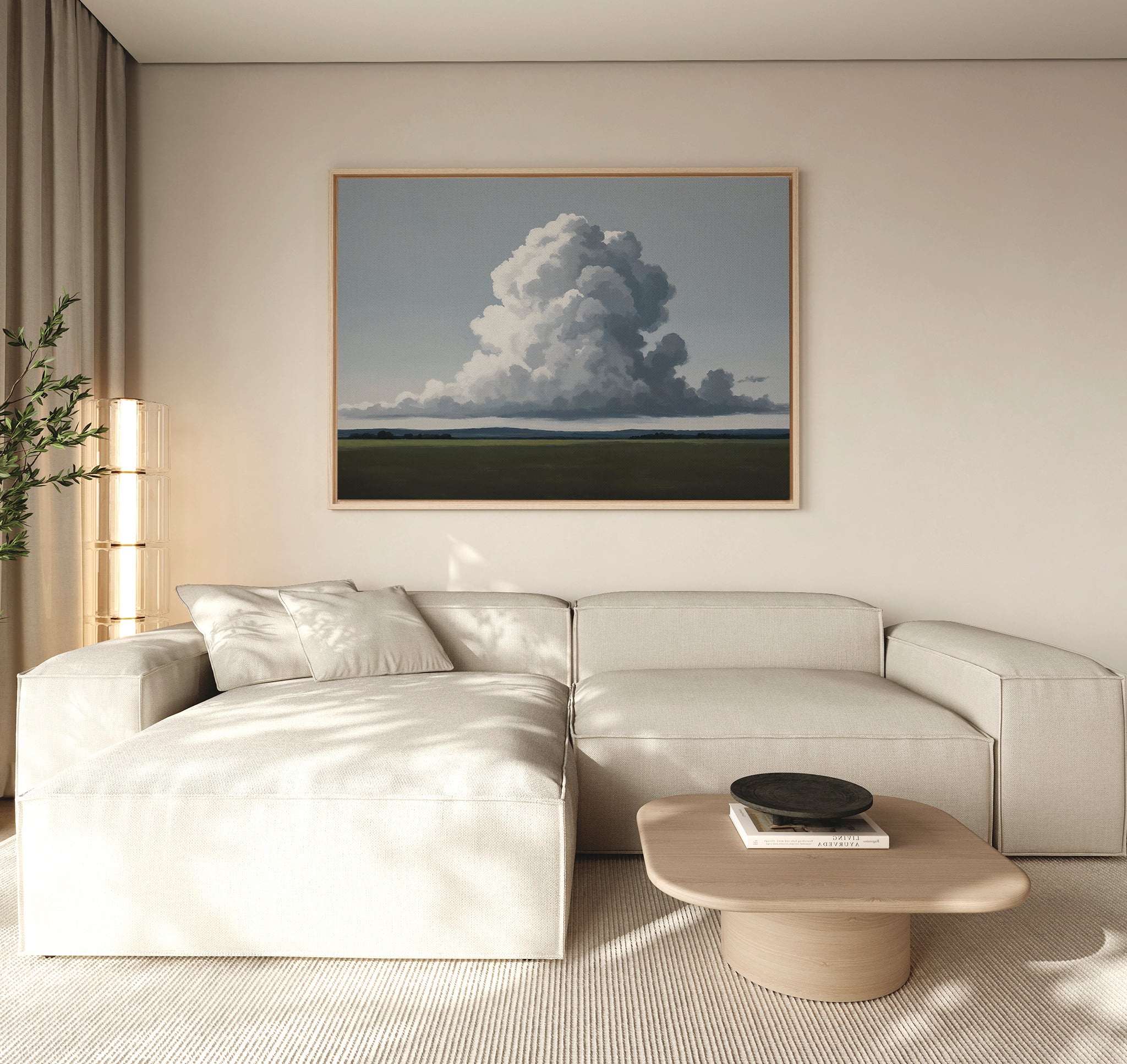 A modern living room with a beige sectional, light wood coffee table, potted plant, and Uplifted Sky Canvas Art depicting clouds and a green field. Neutral tones and soft lighting create a calm, serene atmosphere.