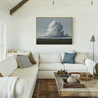 Bright living room with white shiplap walls, a large white sectional sofa with assorted pillows, rustic wood coffee table, woven baskets, and the Uplifted Sky Canvas Art featuring a cloud formation above the couch.