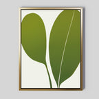 The Verdant Duo Abstract Canvas Art features two large green leaves with clean lines on a white background, framed in a thin gold frame—perfect minimalist decor for your living room.