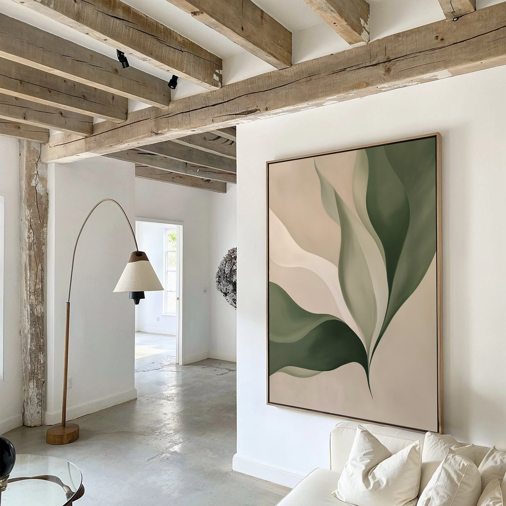 A modern living room with exposed wooden beams, a curved floor lamp, and Verdant Grace wall art featuring green and beige leaves on white. Natural light pours in—perfect for stylish, minimalist decor.