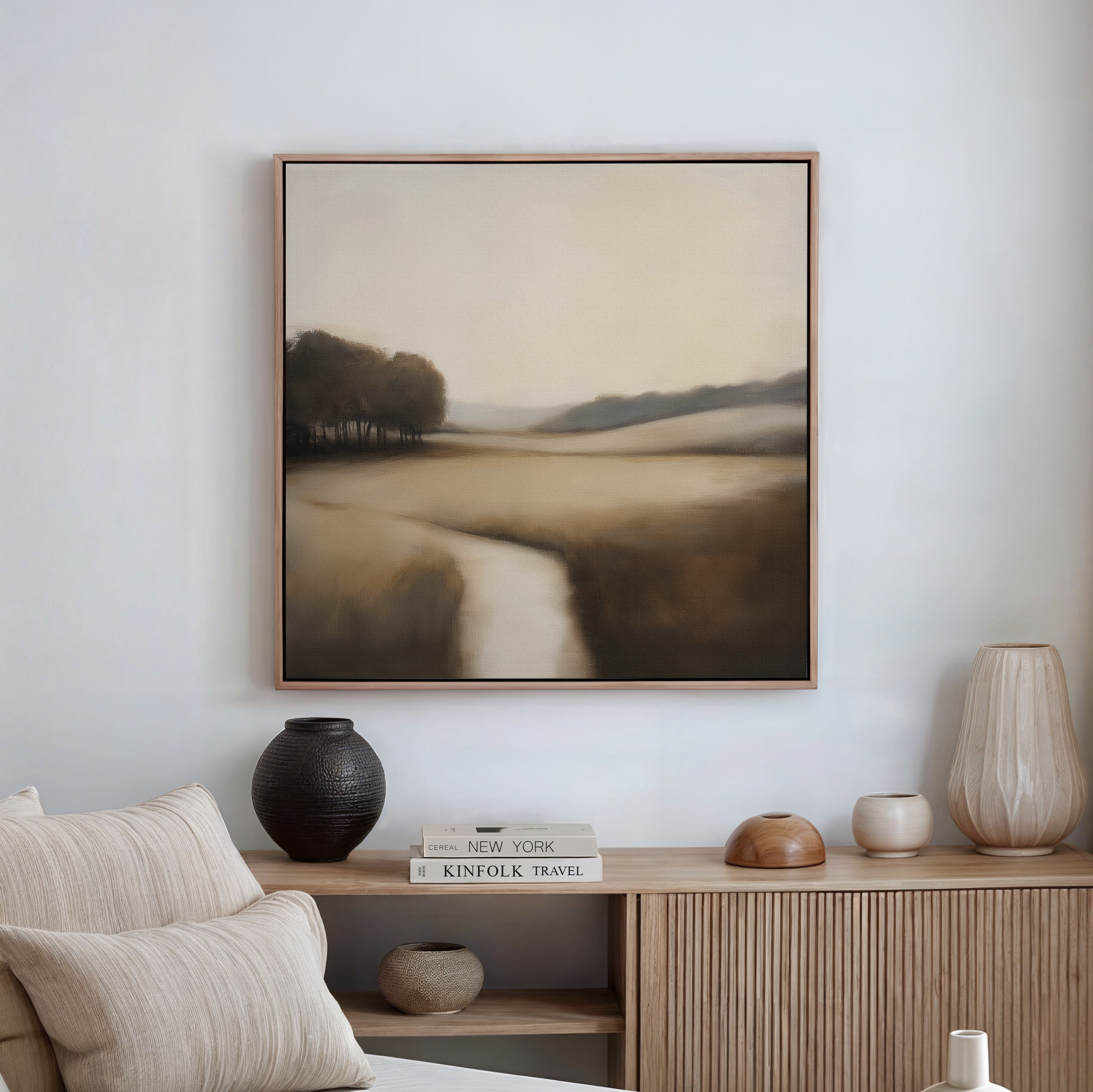 A minimalist living room is elevated by the Vintage Horizon Canvas Art—a large, framed landscape in muted beige and brown tones—paired with a wooden sideboard and neutral decor accents.