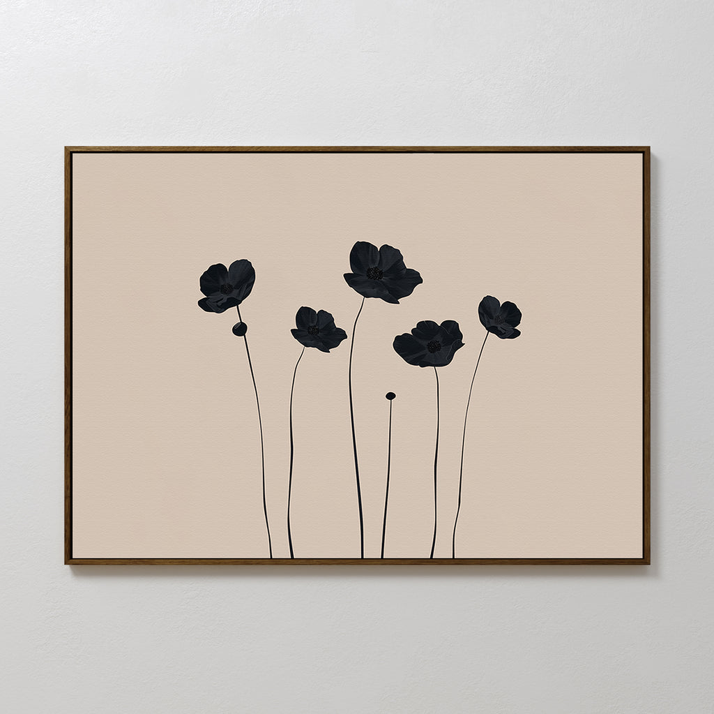 Botanic Abstract Canvas Art showcases six black floral silhouettes with long stems on a beige background, set in a simple brown frame and displayed on a white wall for a modern, minimalist touch.