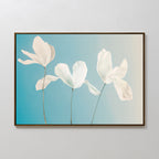 Stellar Flora Abstract Canvas Art: A framed minimalist piece with three delicate white flowers on long stems set against a soft blue gradient, ideal for enhancing your living room decor.