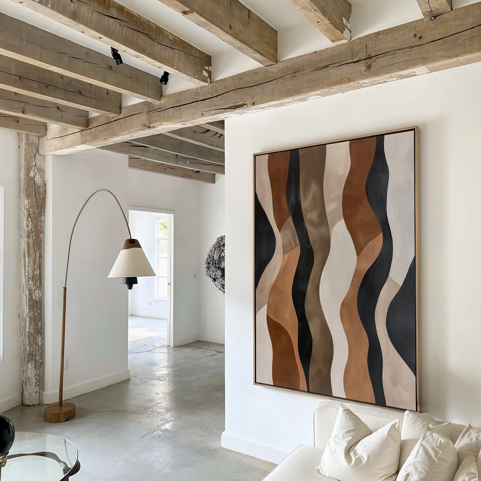 A modern living room features exposed wooden beams and the Wavy Patterns Abstract Canvas Art above a white couch. A curved floor lamp adds style, while natural light enhances the minimalist decor and airy, open feel.