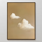 Whispering Clouds framed painting features two fluffy white clouds on a soft, light brown background—perfect minimalist wall art for bedroom or living room decor, shown displayed on a plain white wall.