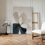 The Whispering Petals Canvas Art - Vertical leans against a white paneled wall beside an empty frame, with a modern black side table holding candles and books, and a wooden chair on herringbone wood flooring nearby.
