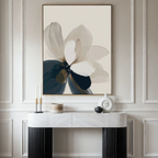 A minimalist room features a marble console, modern decor, and Whispering Petals Canvas Art - Vertical, a neutral and navy abstract flower painting on a paneled wall—perfect for refined living room decor.