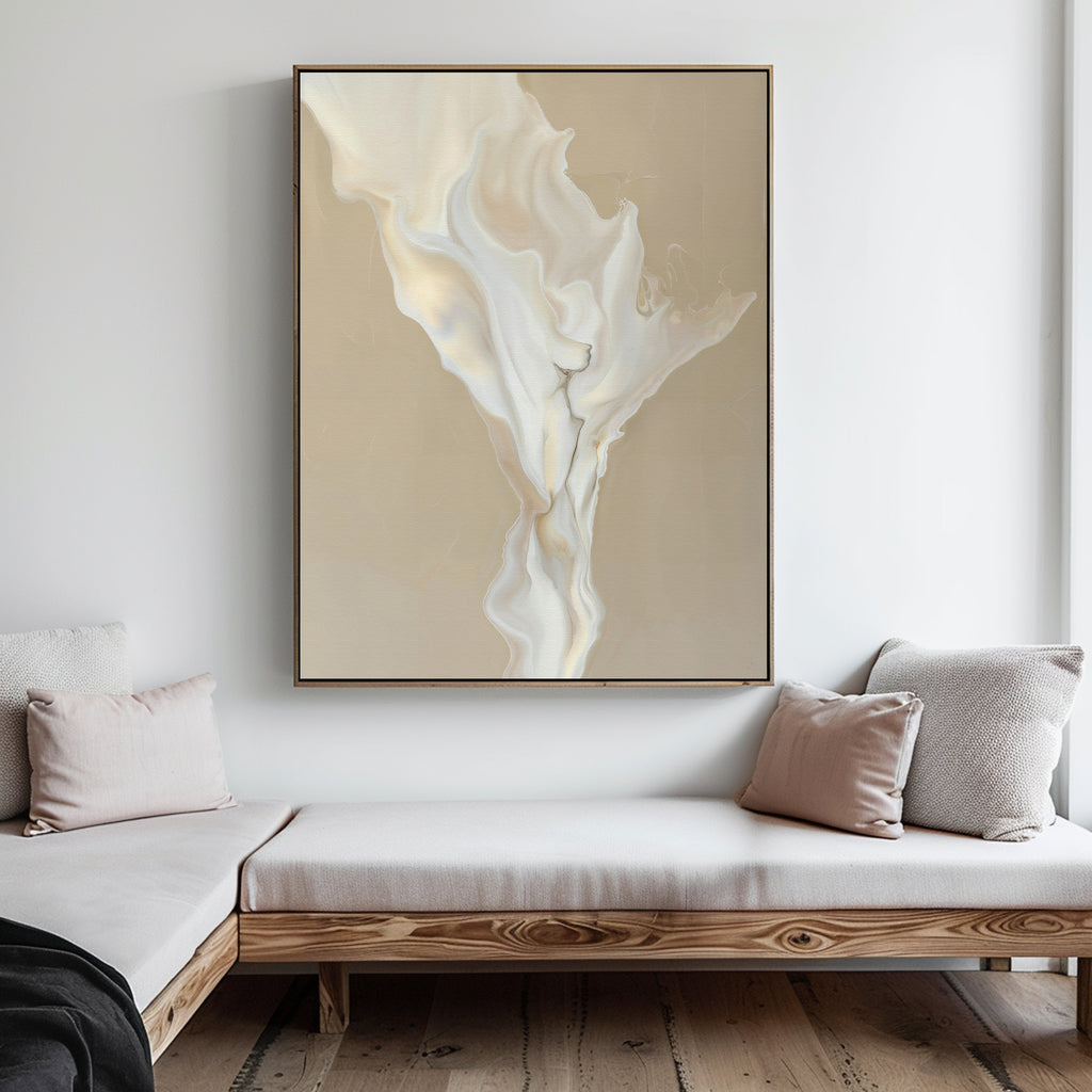 A minimalist living room with light wood furniture, beige and white cushions, and the White Flame Abstract Canvas Art featuring flowing cream and white shapes on a tan background hanging on the wall.