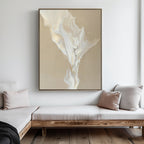 A minimalist living room with light wood furniture, beige and white cushions, and the White Flame Abstract Canvas Art featuring flowing cream and white shapes on a tan background hanging on the wall.