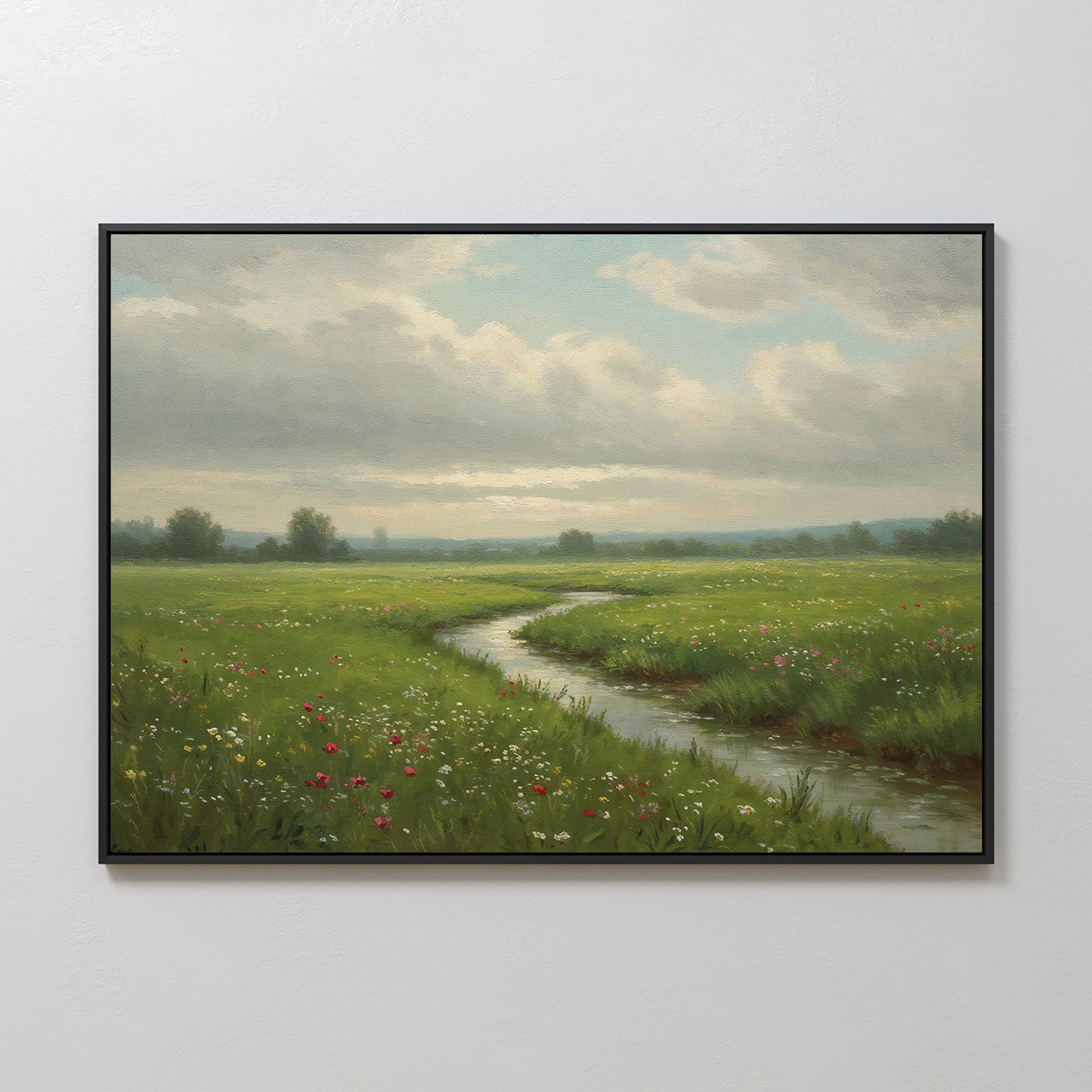 Winding Stream Canvas Art: A framed green landscape print featuring a grassy meadow, wildflowers, and a winding stream beneath a partly cloudy sky—ideal minimalist wall art for any light-colored room.