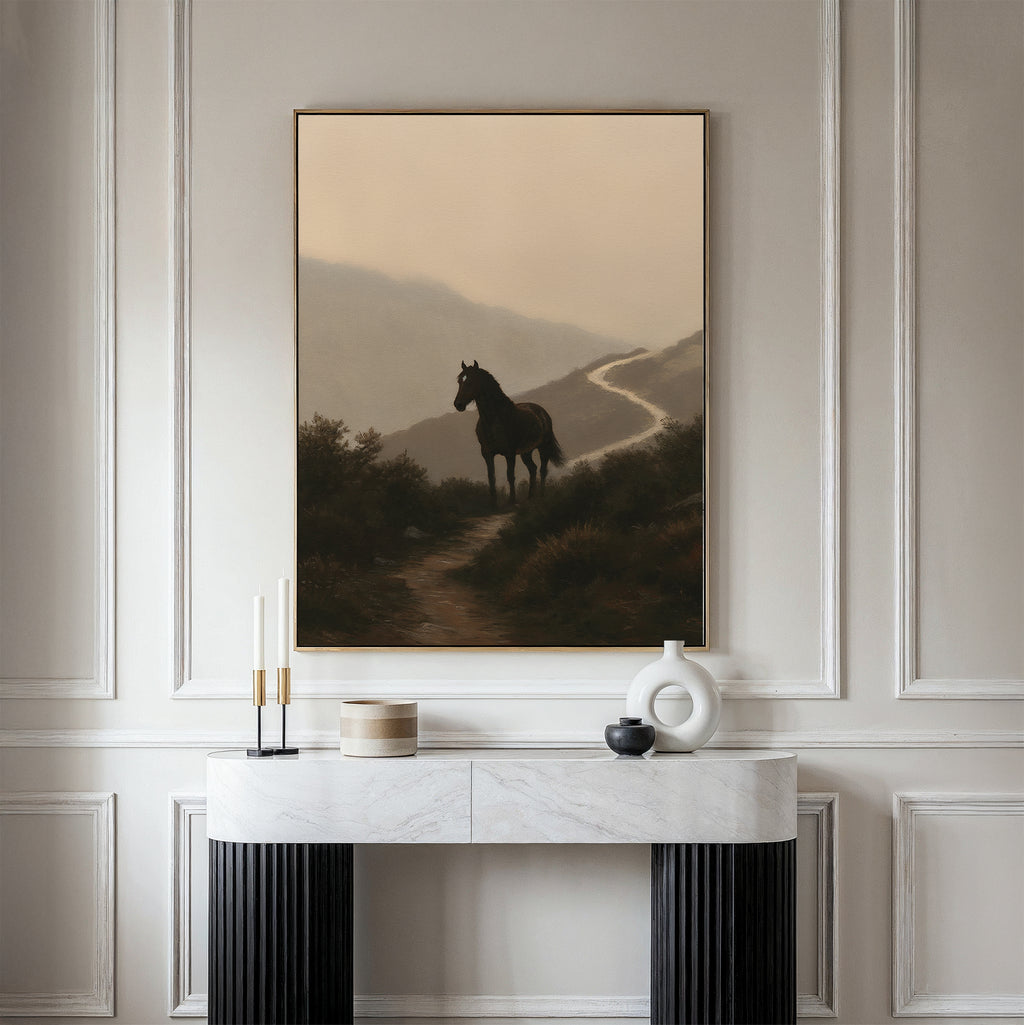 The Winding Trail Canvas Art, featuring a horse on a misty path, hangs above a modern white console table with decor accents against elegant white paneled walls.