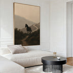 A modern living room featuring a white sectional sofa, round black coffee table, and the Winding Trail Canvas Art—a striking horse silhouette on a misty path—adds an elegant touch of atmospheric nature to your space.